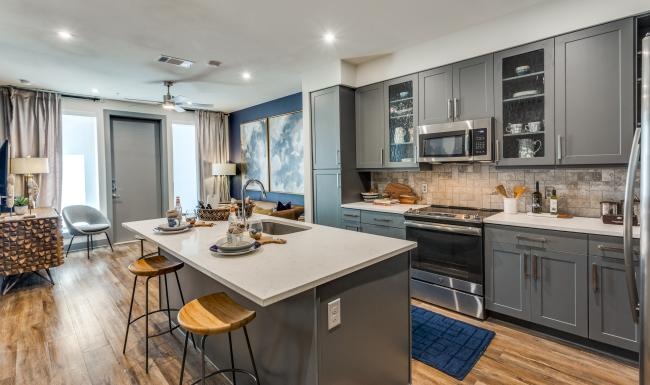 a kitchen with an island a stovetop and a fridge