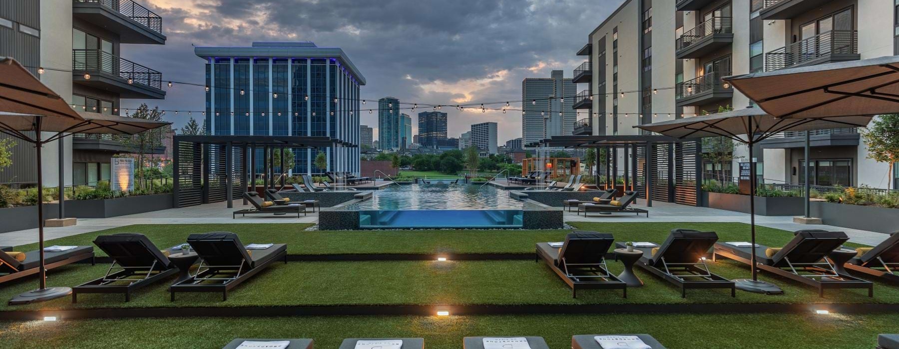 a pool in a courtyard with many lounge chairs