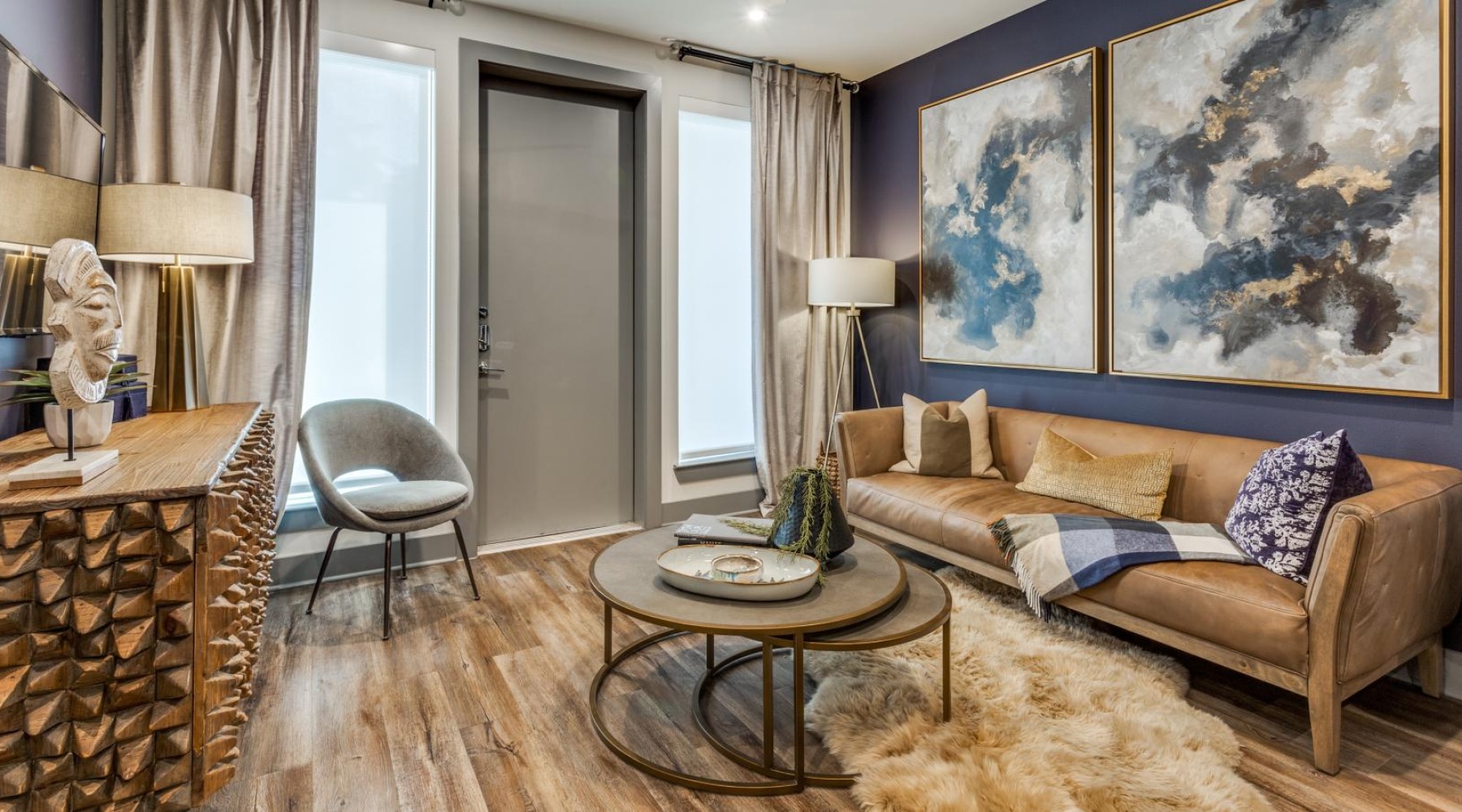 a living room with a couch and a table and windows